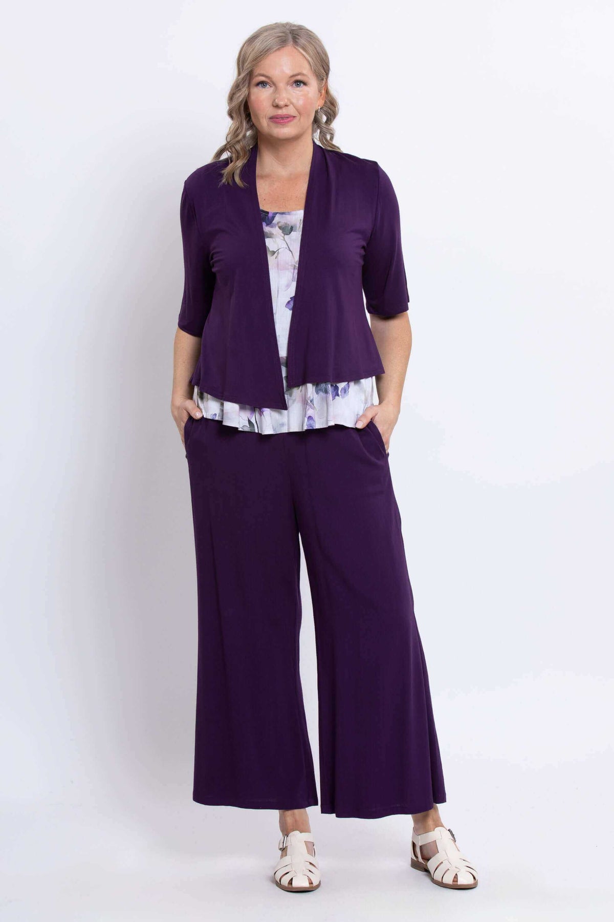 Model layered Ginny floral peplum tank under purple open-front cardigan