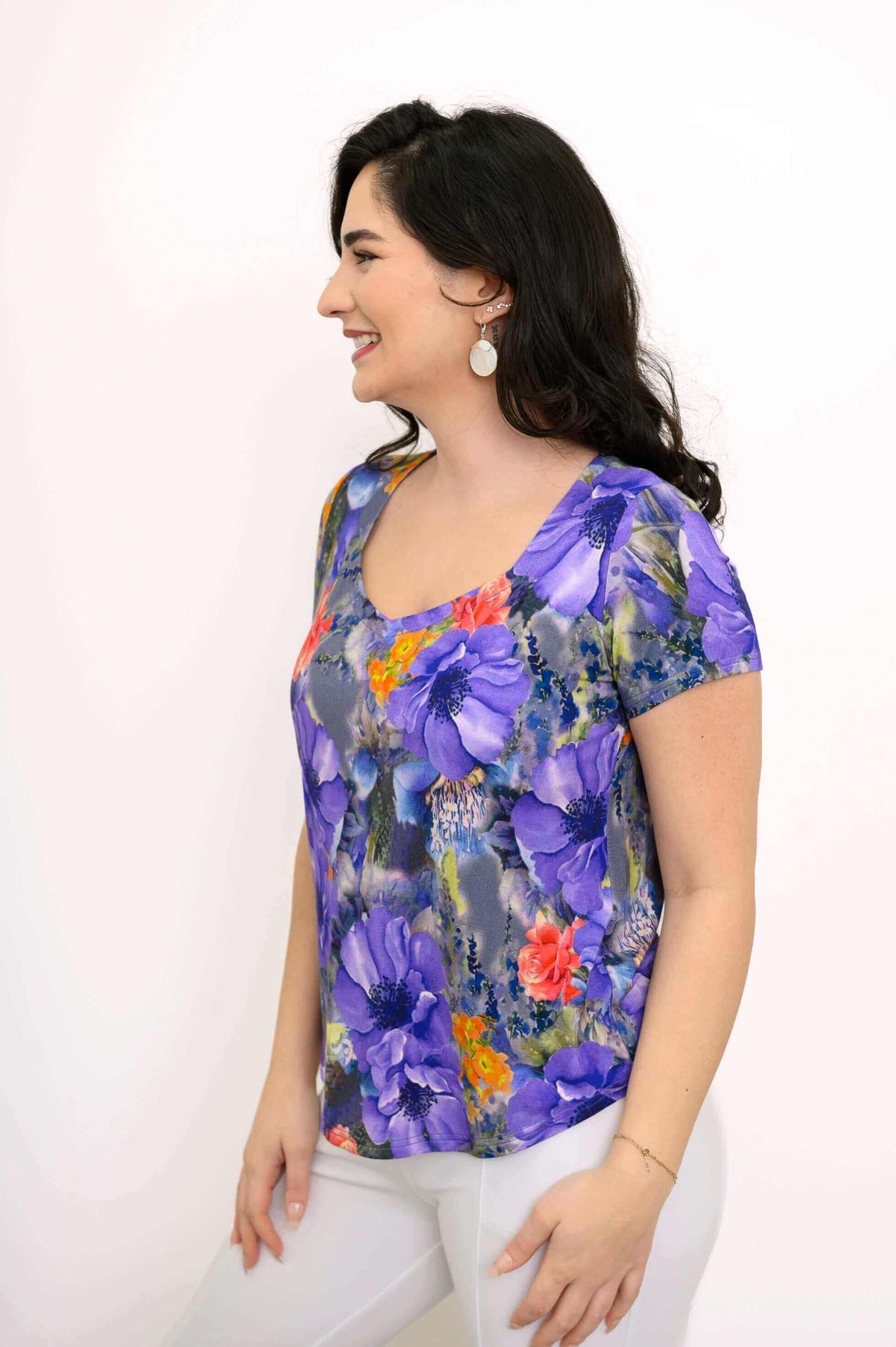 Left side profile of model in floral sweetheart neckline bamboo top and shell pendant earrings
