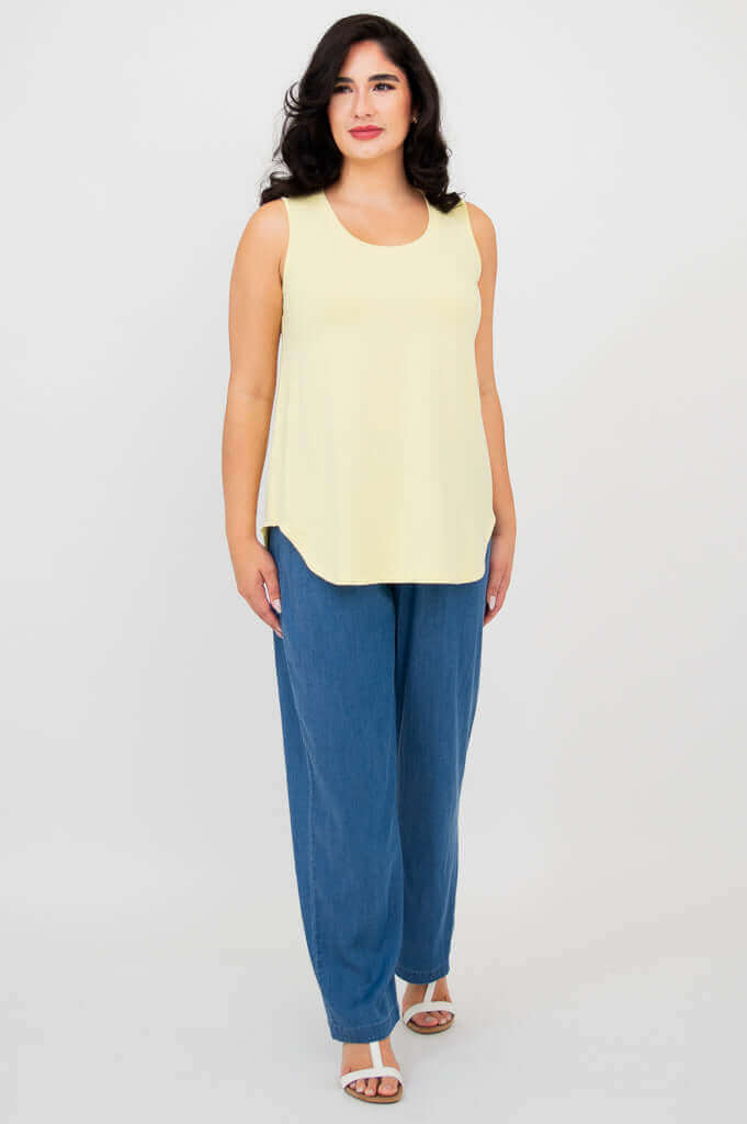 Full body front angle of model in lemon yellow bamboo tank top and blue pants