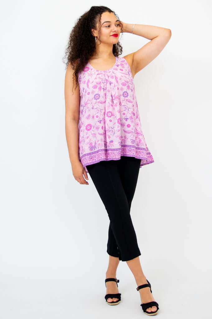 Woman posing in lilac floral pleated tank top, hand in hair