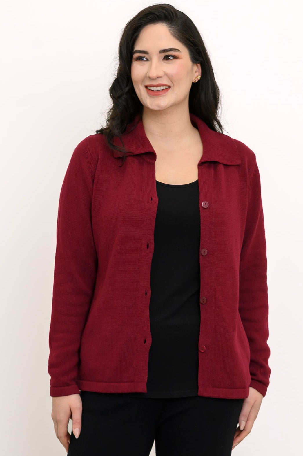 Front view of a woman wearing a rich burgundy button-up knit cardigan layered over a black top and trousers.