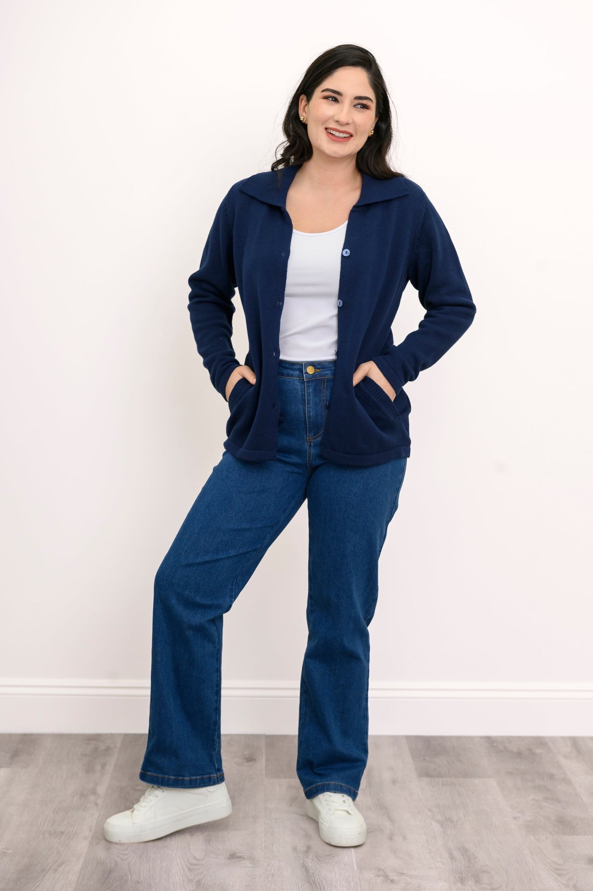 Full body shot of a woman in a comfortable navy collared sweater displaying a fitted silhouette with natural stretch.