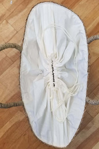 Interior of rattan tote lined with natural cotton and white drawstring closure