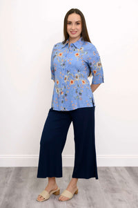 Woman modeling blue floral blouse paired with wide-leg navy pants