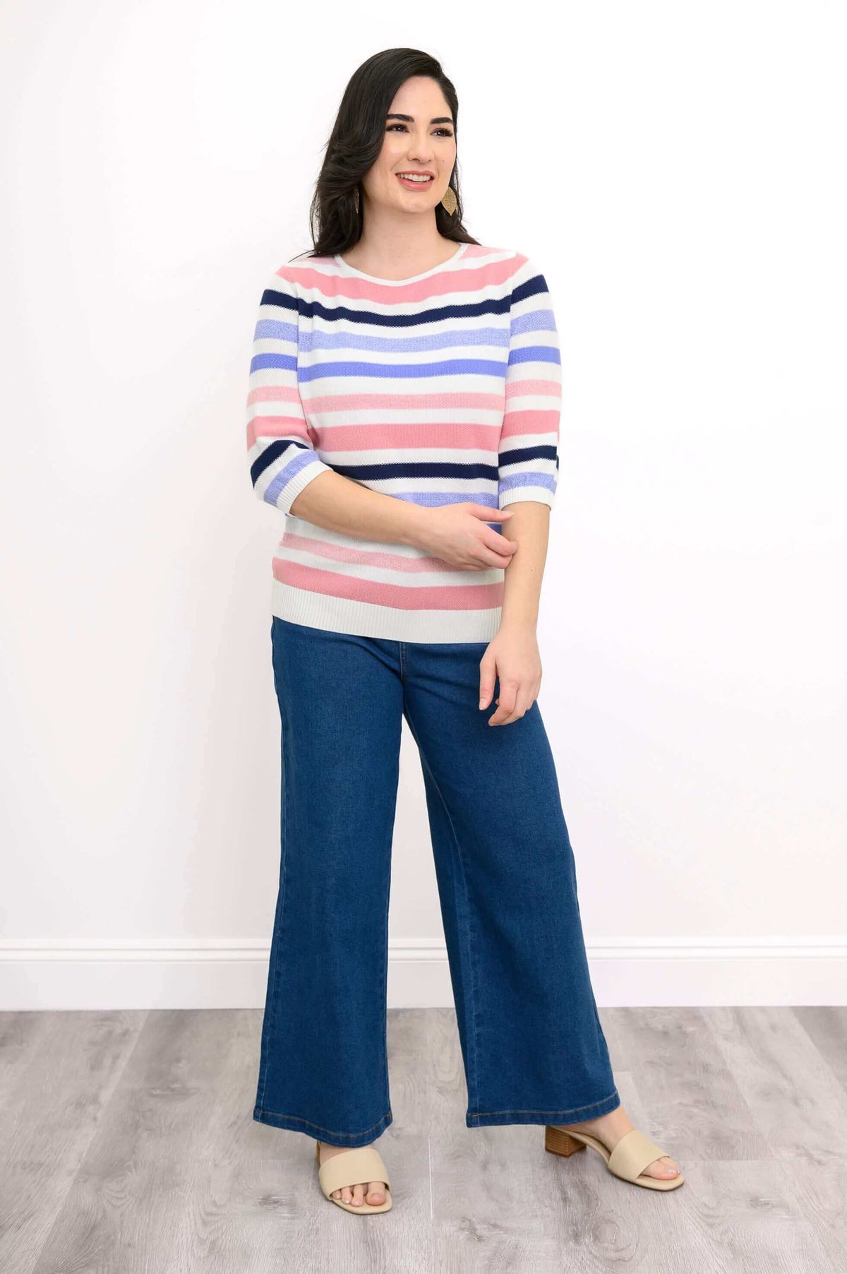Model wearing Sweater with pink, navy, lilac, and white stripes and blue wide-leg jeans