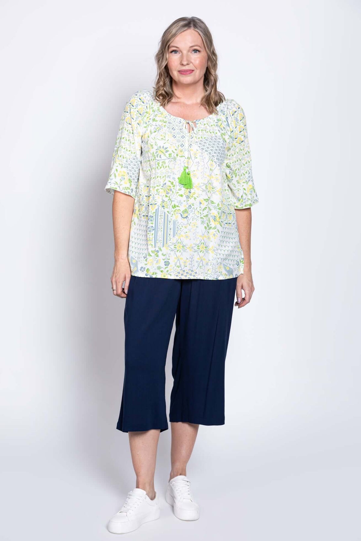Full body view of woman in Luna Boho Peasant Top and navy pants