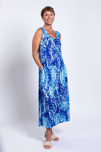 Woman posing in Madison blue printed maxi dress with hands in pockets