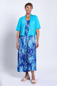 Woman wearing Madison blue printed maxi dress paired with a short turquoise cardigan