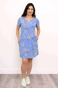 Woman wearing blue floral Maggie shift dress with hands in pockets, front-facing