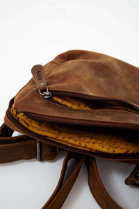 Close-up of the main zippered compartment revealing a yellow branded fabric interior lining