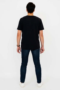 Man in black t-shirt and jeans, back view standing