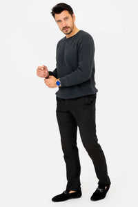 Man in charcoal ribbed sweater adjusting his sleeve, side angle