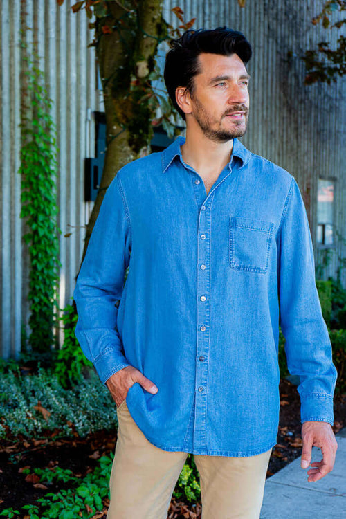 Man standing outdoors in light blue button-up shirt with collar and front pocket
