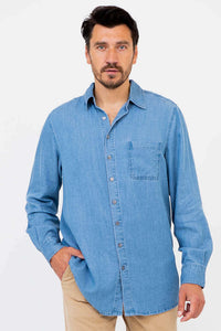 Man wearing a light blue button-up shirt with collar and front pocket, hand in pocket