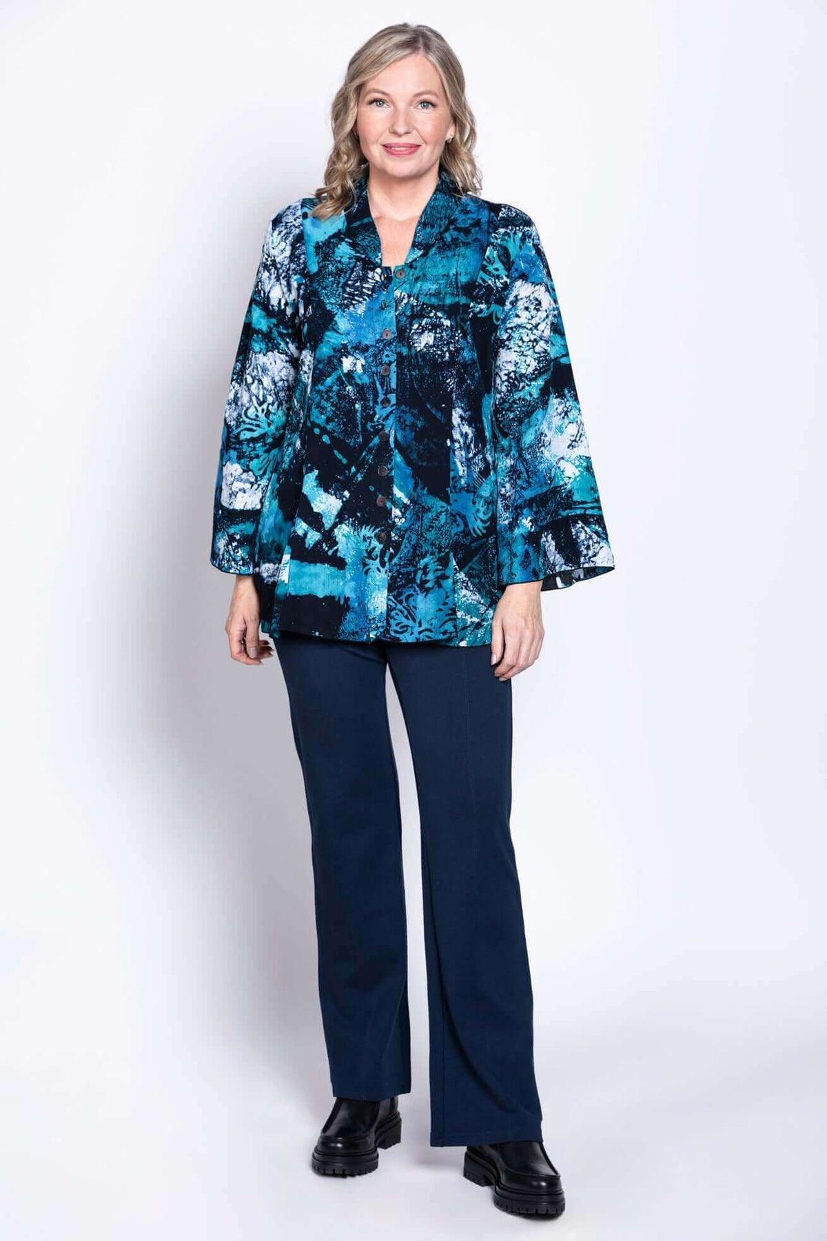 Woman modeling blue abstract blouse with 3/4 bell sleeves and button front, full body