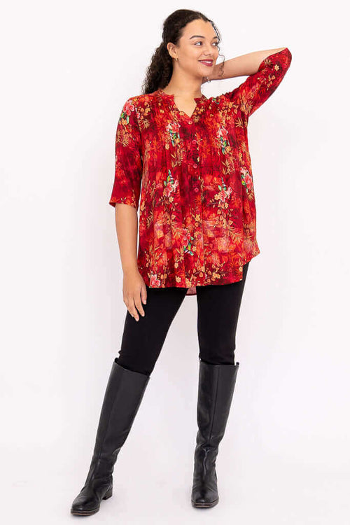 Margate blouse in red floral print, model posing with arm raised