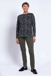 Woman modeling dark floral hip-length top with olive green straight pants