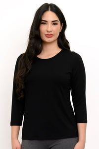 Woman wearing a black long-sleeve top against a white background, front view