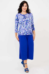 Woman walking in a blue watercolor floral tee with matching wide-leg pants