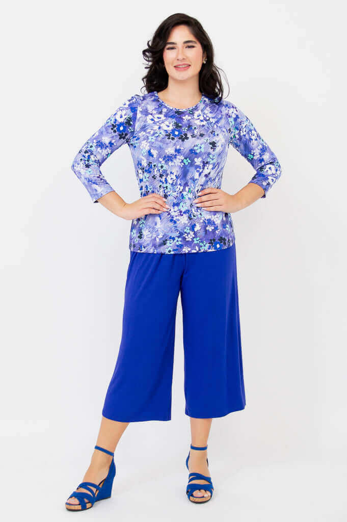 Full body view of woman in a blue floral tee and matching wide-leg pants