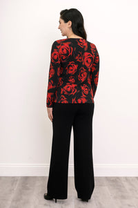 Back view of a women's round neck red floral print shirt, styled with dark trousers against a white background.