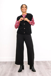 Front view of a women's black flat-knit layer with marled buttons, styled casually on a white background.