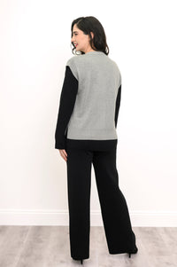 Back view of a light gray knit vest, highlighting the flattering extended shoulder cut and deep ribbed waist.