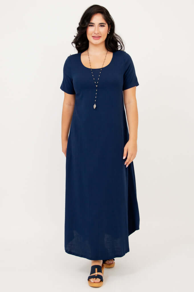 Woman facing forward wearing flowing navy maxi dress with short sleeves