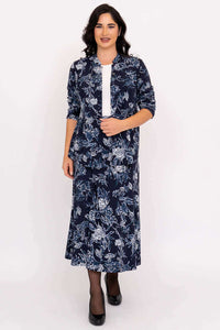 Model wearing matching navy floral jacket and midi skirt, standing and smiling