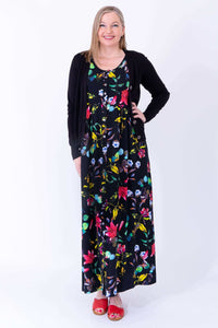 Maxi floral dress styled with black cardigan, modeled by woman in red sandals
