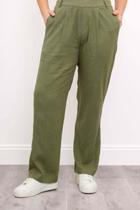 Front view of olive green pants styled with white sneakers