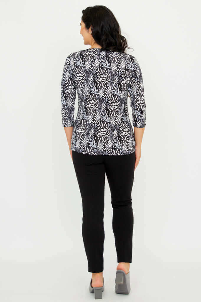 Back view of model wearing Mia Top in Black Feather with black pants