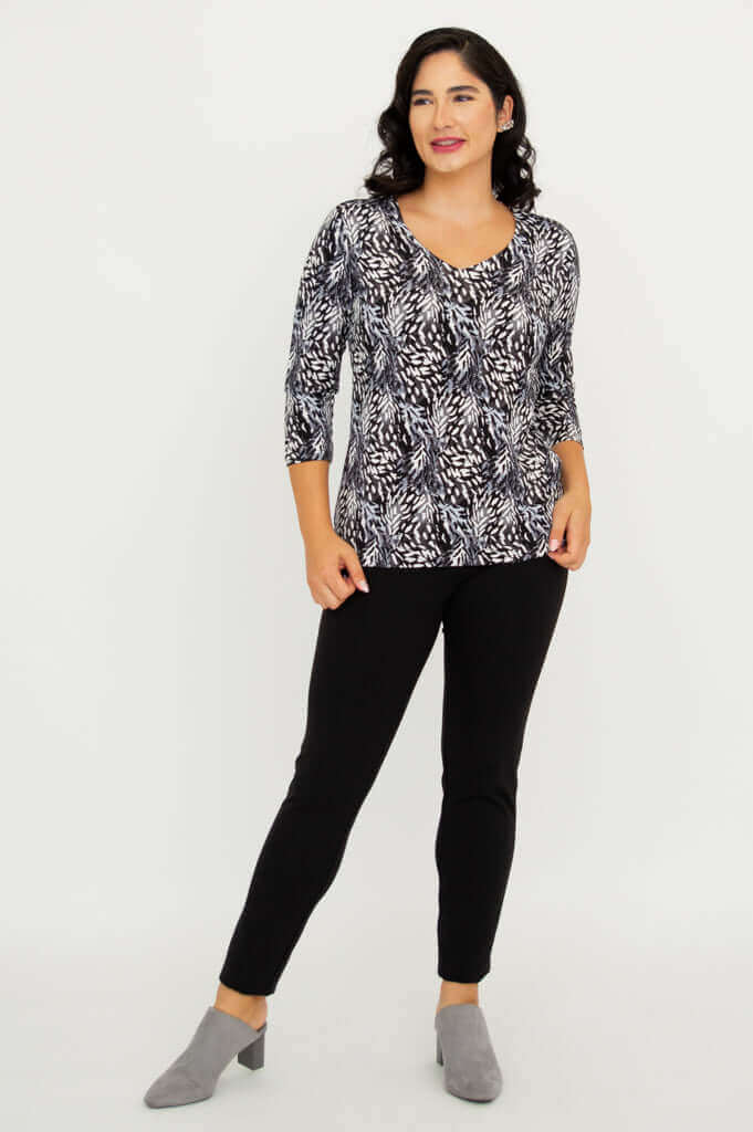Model posing in Mia Top Black Feather, with one hand in pocket, black pants