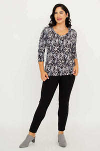 Model posing in Mia Top Black Feather, with one hand in pocket, black pants