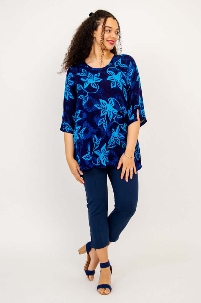 Full-length view of woman modeling a blue floral Palace Blouse and navy pants
