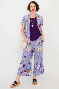 Model wearing Landon Capri pants and matching floral shirt with purple top
