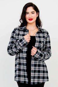 Model adjusting collar of Georgia plaid shirt over black top