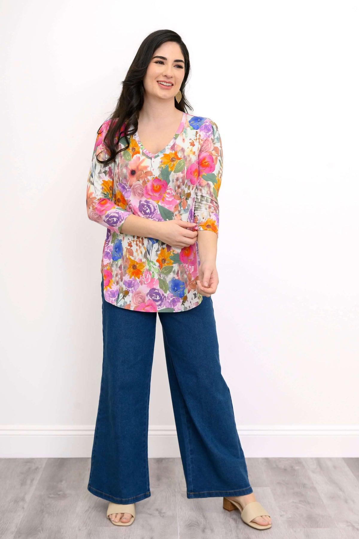 Woman smiling and adjusting sleeve of a colorful floral bamboo top