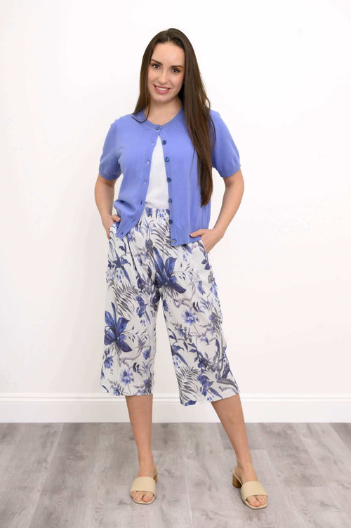 Model wearing blue floral capri Pant with purple short-sleeve cardigan