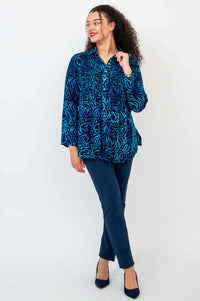 Model looking sideways in Cindy smocked blue swirl shirt and navy pants
