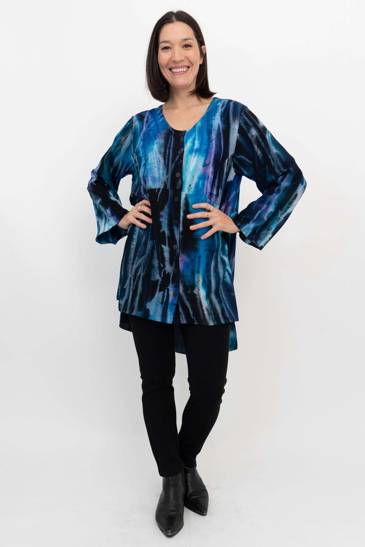 Full body front view of model in Darla blouse with hands on hips and black pants