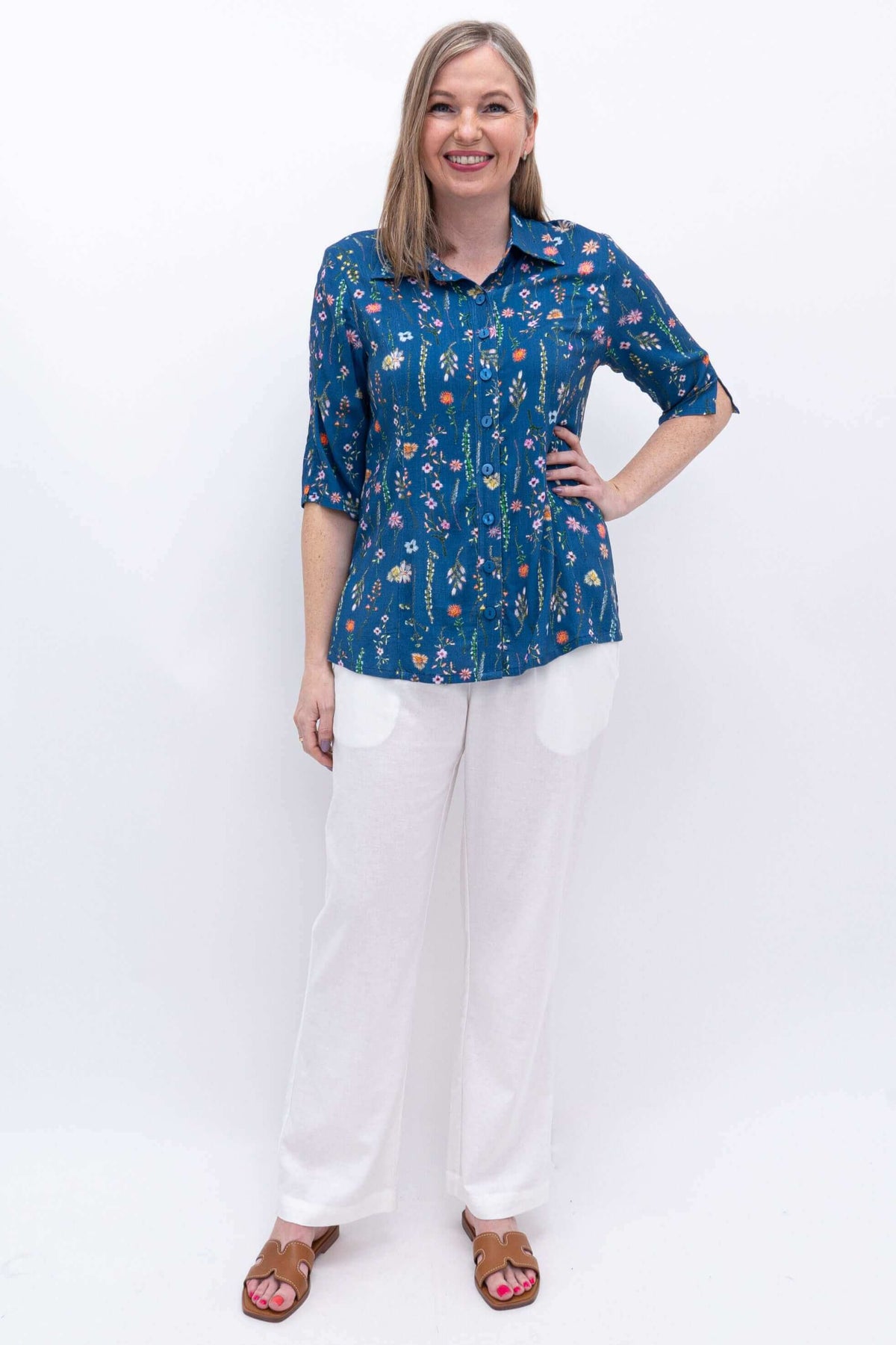 Model wearing white Melodie Pant with blue floral top, front view