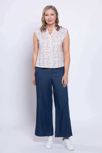 Model standing in Paula Top and wide navy pants with white sneakers