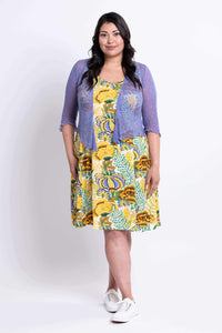 Model wearing a yellow floral dress styled with a lavender cardigan, front view