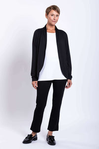 Woman modeling black French Terry jacket, white shirt, and black pants with hands at sides