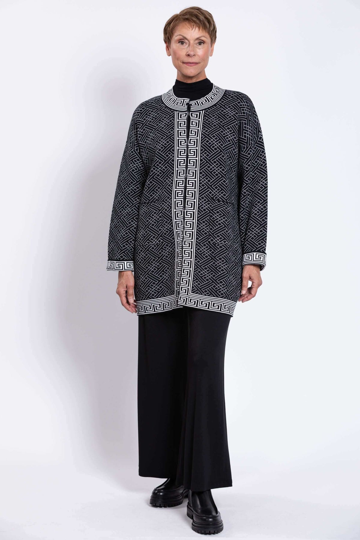 Model in a black and white geometric cardigan paired with wide-leg black pants