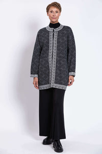 Model in a black and white geometric cardigan paired with wide-leg black pants