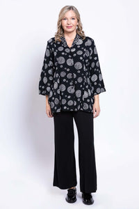 Woman modeling a black blouse with white circle print and matching black wide-leg pants