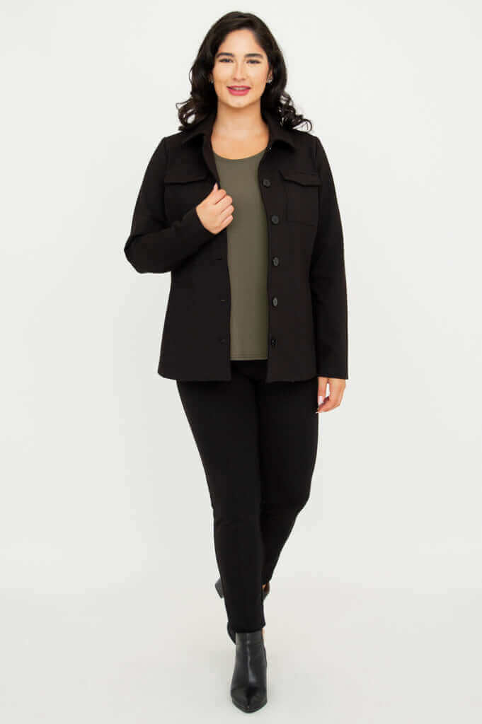 Model walking in black jacket, olive green top, and black pants
