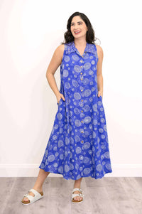 Model hands in pockets wearing a blue A-line sleeveless dress with white circular swirl designs
